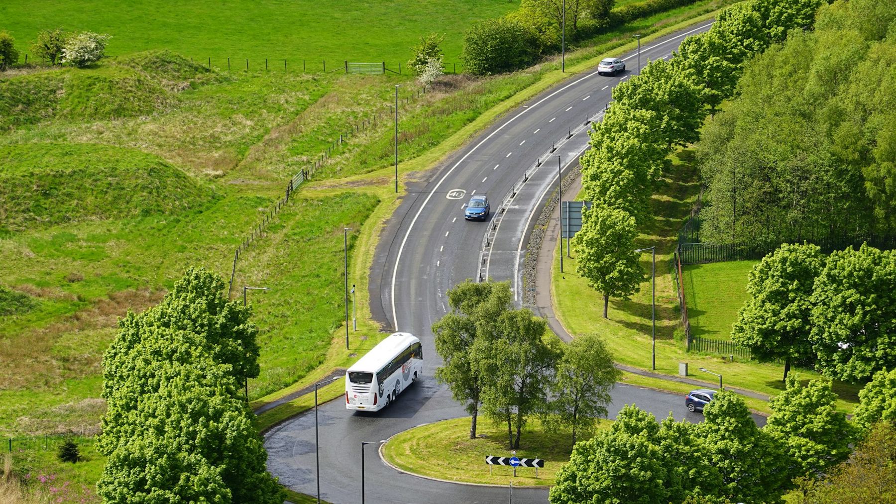 Autobús interurbano tomando una curva en una carretera entre colinas