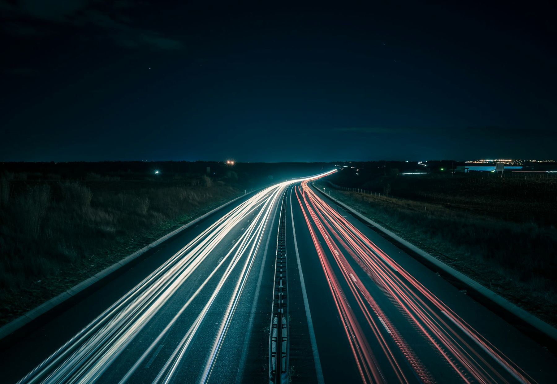Estela de luces de vehículos en una autopista de noche